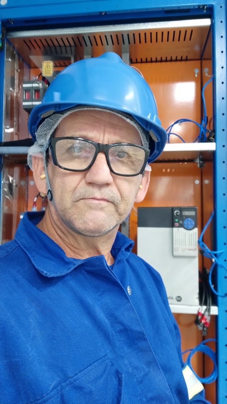 Dulcival Rios, eletricista residencial, em frente a um quadro de distribuição